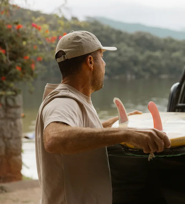 A man in a cap beside a lake on a summer morning