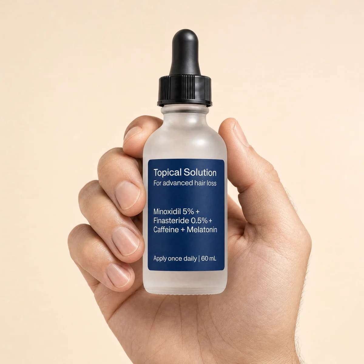A hand holding the topical solution dropper bottle